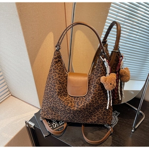 Détail du cabas léopard avec poignées en cuir marron et breloque ours en peluche accessoire