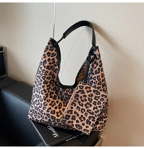 Detail of leopard print hobo tote bag and matching mini pouch on a leather seat
