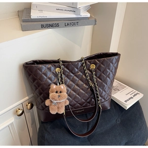 Détail du sac cabas matelassé marron avec bandoulière chaîne et breloque ours