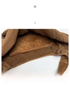Detail view of the deep brown suede tote interior with a secure metal zipper pocket