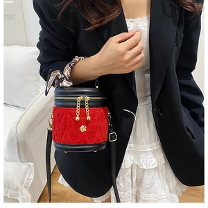 Detail der roten Samt-Eimertasche mit Steppmuster und seidengewickeltem Handgriff