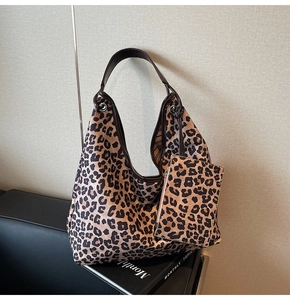 Close-up of leopard print tote bag with matching small zippered coin pouch on a magazine