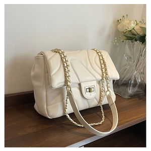 Detailed view of the quilted leather chain bag with a gold metal twist lock and strap