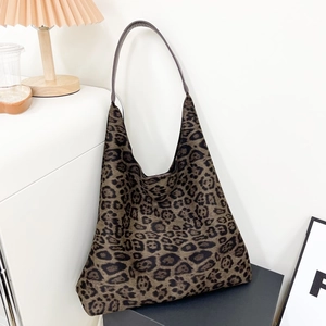 Sac cabas hobo à imprimé léopard avec fines lanières noires dans un studio minimaliste
