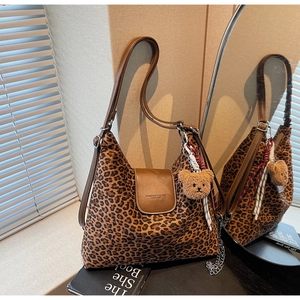 Détail du sac cabas à motif léopard avec lanières en cuir et charmant ours en peluche
