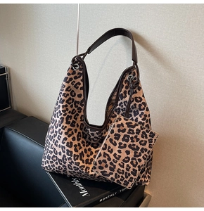 Detail of leopard print hobo bag with matching small pouch and brown leather straps