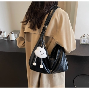 Detail of black glossy pleated leather shoulder bag with triangle logo and plush charm