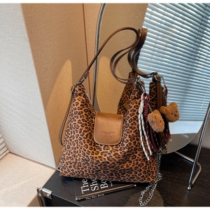 Détail du sac cabas imprimé léopard avec bandoulière en cuir marron et breloque ourson
