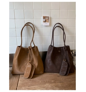 Close-up of caramel and dark coffee suede tote bags with fine leather handles