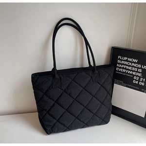 Gros plan du sac cabas matelassé noir avec motif à losanges et fines bandoulières