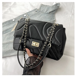 Detail of black quilted leather shoulder bag with gold twist lock and chain strap