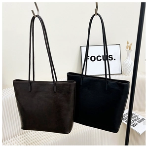 Detail view of large minimalist tote bags in dark coffee and black textured PU leather