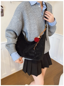 Detail der schwarzen matten Hobo-Tasche mit rotem Bommel und verstellbarem Gurt