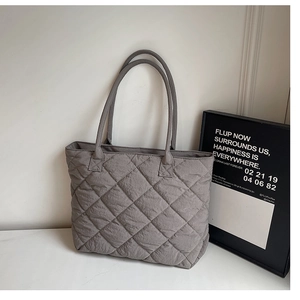 Détail du sac cabas matelassé gris foncé avec grandes surpiqûres et texture souple