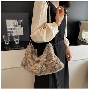 Détail du sac cabas en fausse fourrure taupe avec bandoulière chaîne dorée sur mannequin