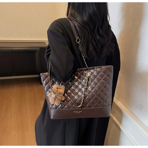 Détail du sac cabas matelassé marron avec chaîne dorée et breloque ourson