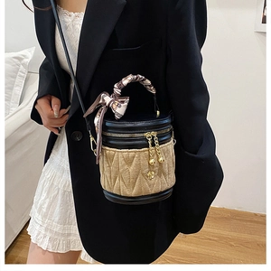 Detailansicht der gesteppten Beuteltasche mit Seidentuchgriff und goldener Blume
