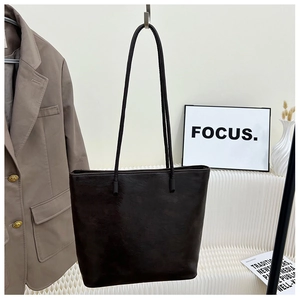 Detail of vintage faux leather tote bag showing fine grain texture and slender shoulder straps