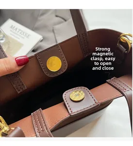 Detail of strong magnetic gold buckles on a dark brown suede bucket bag interior