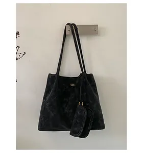 Close-up of black retro tote bag with golden logo detail and detachable mini pouch