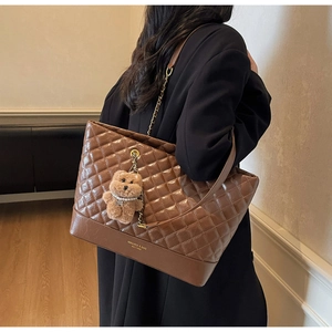 Détail du sac cabas matelassé marron avec bandoulière chaîne et breloque ourson