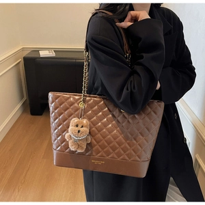 Détail du sac cabas matelassé marron avec chaîne en métal et breloque ours mignon