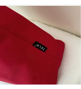 Close-up of red canvas material texture and woven brand label on the shoulder bag