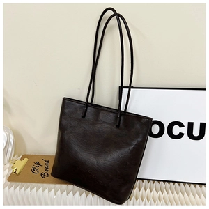 Detailed view of the dark brown leather texture on a stylish commuter tote bag