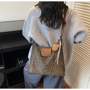 Détail du grand sac cabas à imprimé léopard avec rabat en cuir brun et pendentif ours