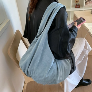 Detailed view of light blue suede tote bag showing its soft texture and slouchy design