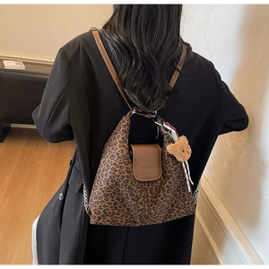 Détail du sac léopard avec rabat en cuir marron et breloque ours en peluche mignonne