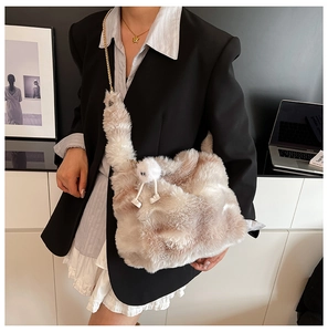 Détail d'un sac cabas en peluche en forme de cygne avec chaîne dorée et breloque