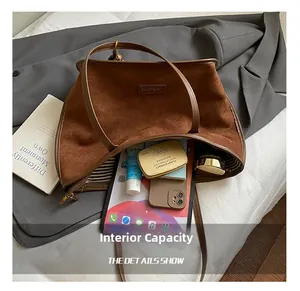 Vista interna della grande borsa tote in pelle scamosciata marrone con oggetti quotidiani