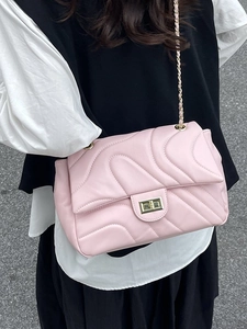 Pink quilted crossbody bag with golden chain strap and S-shaped stitching detail