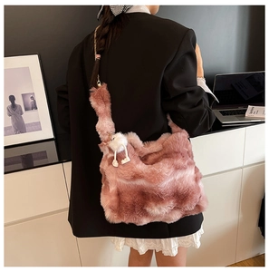 Détail d'un sac cabas en fausse fourrure mauve avec charm pelucheux et bandoulière large