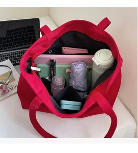 Close-up of red canvas tote bag interior showing large capacity and zipper pocket