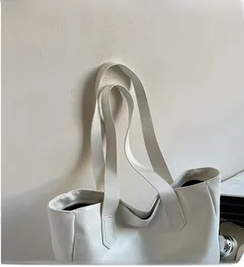 Detail of white PU leather tote bag showing fine texture and wide shoulder straps