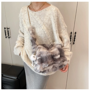 Detail of grey and white faux fur tote bag with fluffy eye charm and silver chain strap