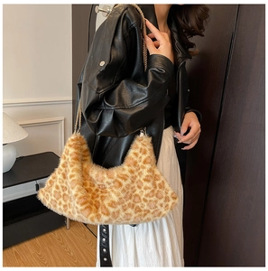 Détail du sac bandoulière en peluche léopard avec chaîne dorée porté par un mannequin