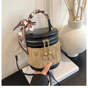 Detail der gesteppten Wildleder-Beuteltasche mit Kamelien-Anhänger und Seidenschal-Griff