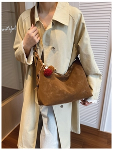 Brown frosted suede hobo bag with red pompom charm and wide shoulder strap