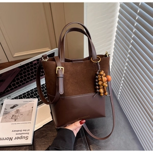 Détail du sac seau marron café avec texture daim mat et breloque en perles de bois