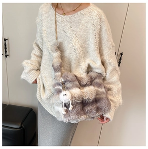 Détail du sac en fausse fourrure à motif marbré, chaîne dorée et breloque en peluche