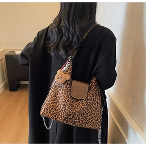 Détail du sac cabas léopard avec rabat en cuir marron et pendentif ours en peluche