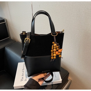 Détail du sac seau noir mat avec des perles en bois colorées et une bandoulière réglable