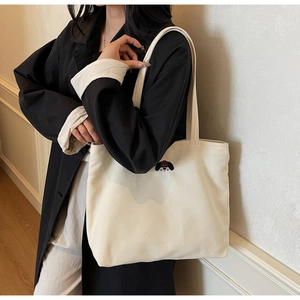 Detail of cute puppy embroidery on cream-white canvas tote bag for casual commute