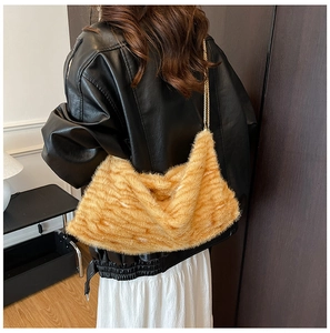 Gros plan d'un sac bandoulière en fausse fourrure pelucheuse avec chaîne dorée chic
