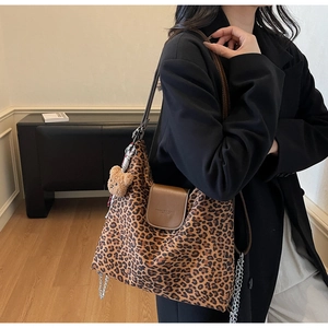 Détail du cabas léopard avec rabat en cuir marron et pendentif ours en peluche stylé