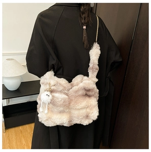 Détail d'un sac cabas en peluche avec oreilles de chat, chaîne métal et pendentif poupée
