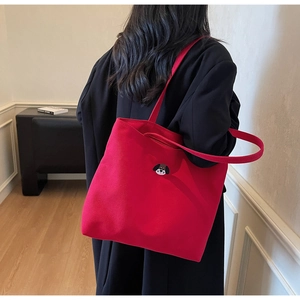 Red canvas tote bag with dog embroidery shown on model for daily commuting fashion